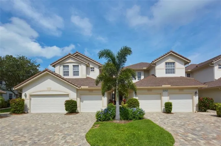 View of front of property with stucco siding, driveway, and a garage