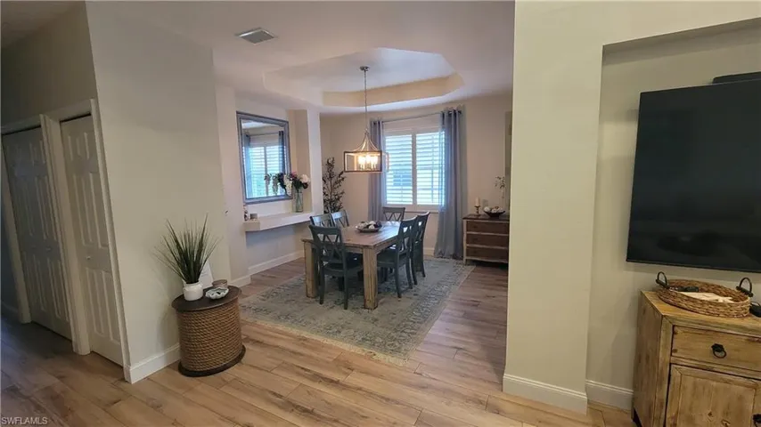 Dining area with a raised ceiling and light wood-style floors