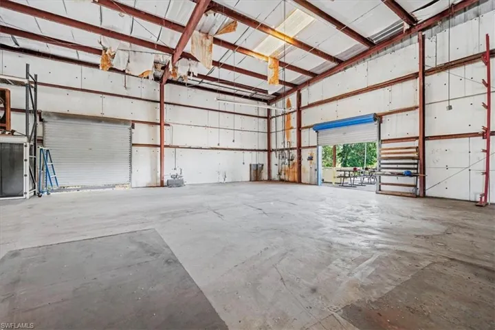 Spacious warehouse interior featuring exposed metal beam construction and concrete flooring