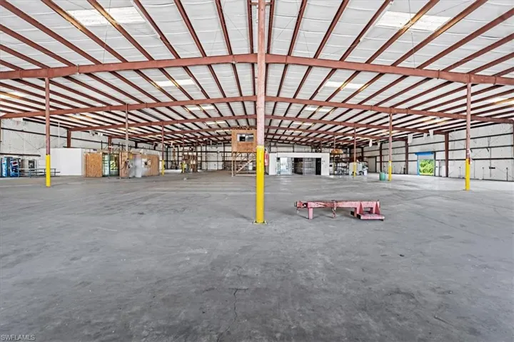 Spacious industrial warehouse featuring an expansive concrete floor and high ceilings with exposed structural beams