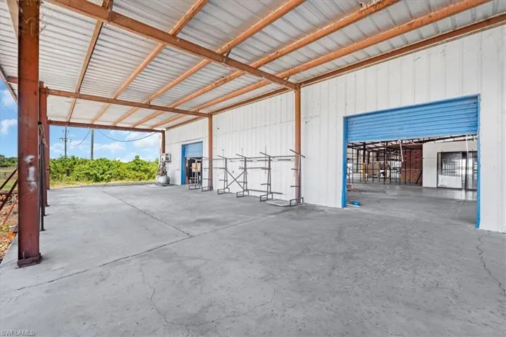 Covered concrete pad featuring a metal roof structure with exposed beams