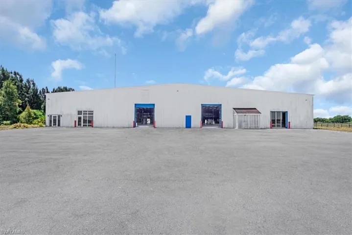 Expansive industrial building with a large paved parking area