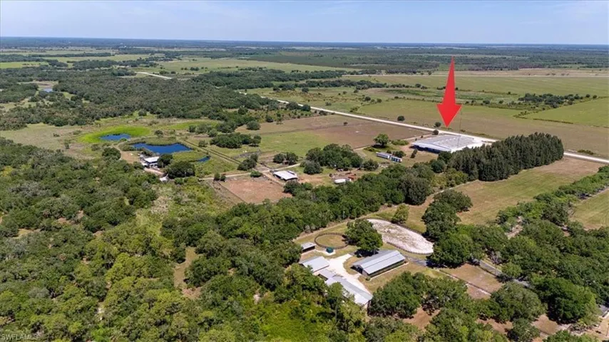 Expansive rural property featuring multiple structures, verdant trees, and several ponds
