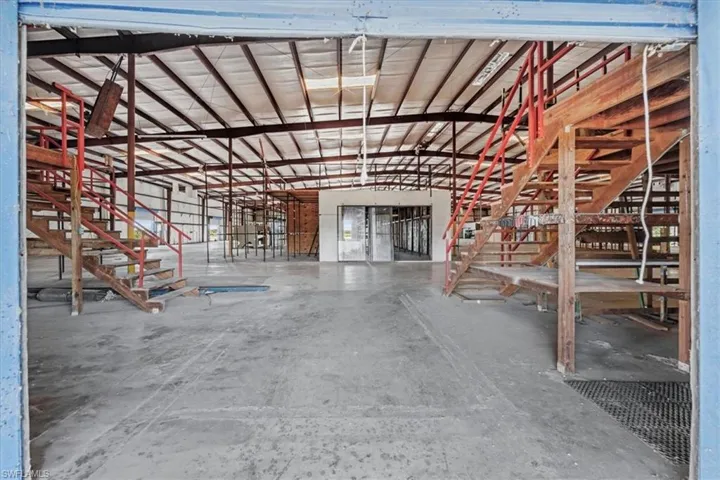 Open-concept commercial space featuring concrete flooring and a high, exposed ceiling structure