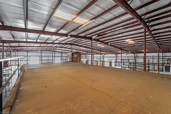 Expansive mezzanine level featuring a plywood floor and black metal railing