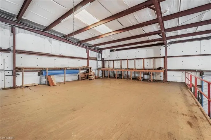 Spacious mezzanine level featuring a wood floor and red metal railing
