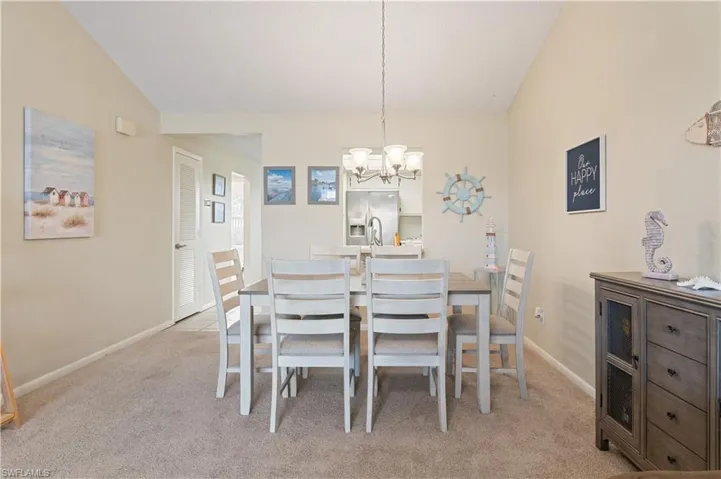 Dining space featuring lofted ceiling, a chandelier, and light colored carpet