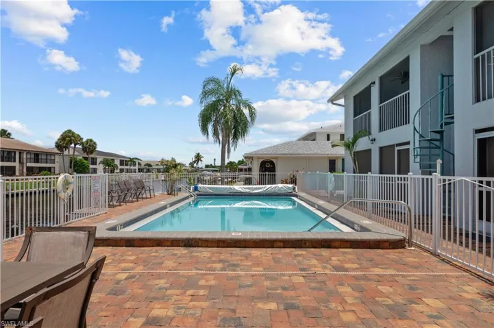 Community pool with a patio, a residential view, outdoor dining area, and a balcony