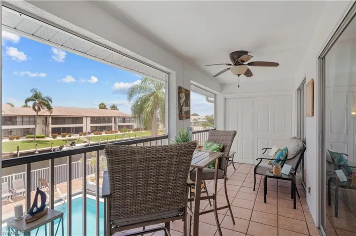 Sunroom / solarium with ceiling fan and a balcony