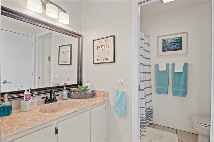 Full bathroom with a shower with shower curtain, vanity, and light tile patterned floors