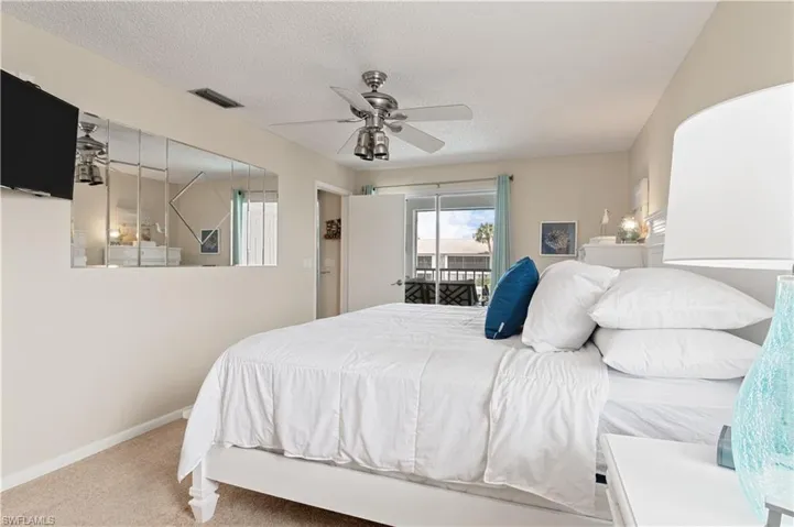 Carpeted bedroom featuring access to exterior, ceiling fan, and a textured ceiling