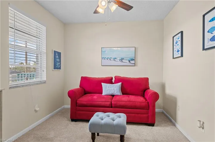Sitting room with carpet flooring, ceiling fan, and a textured ceiling