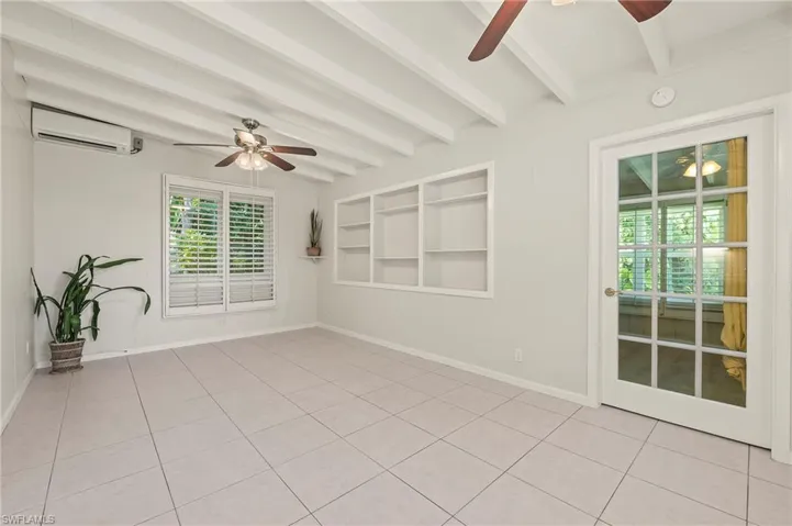 Unfurnished room with light tile patterned floors, a wealth of natural light, a ceiling fan, and a wall mounted AC