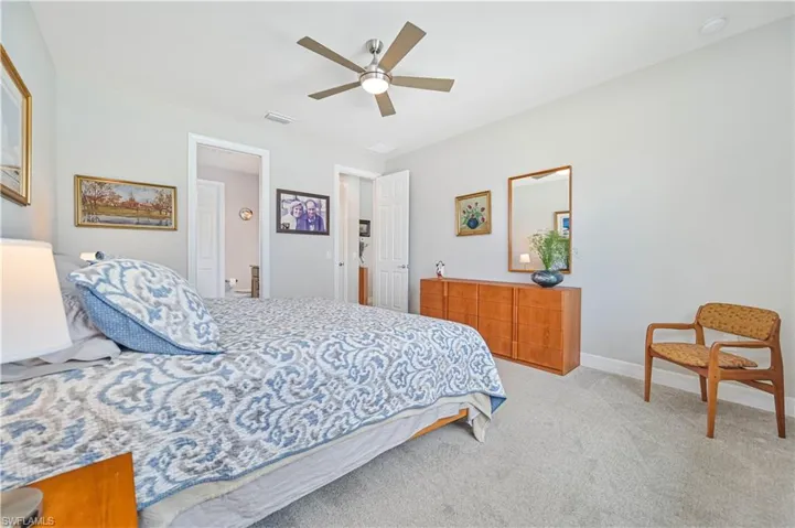 Bedroom with ceiling fan and light carpet