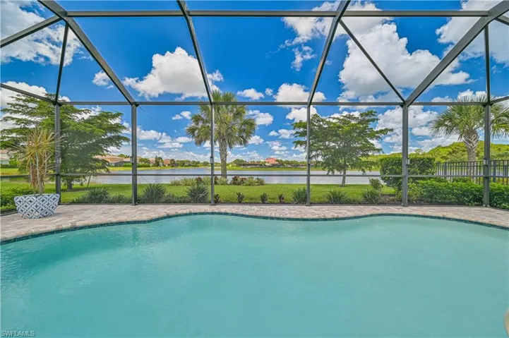 View of pool featuring glass enclosure and a water view
