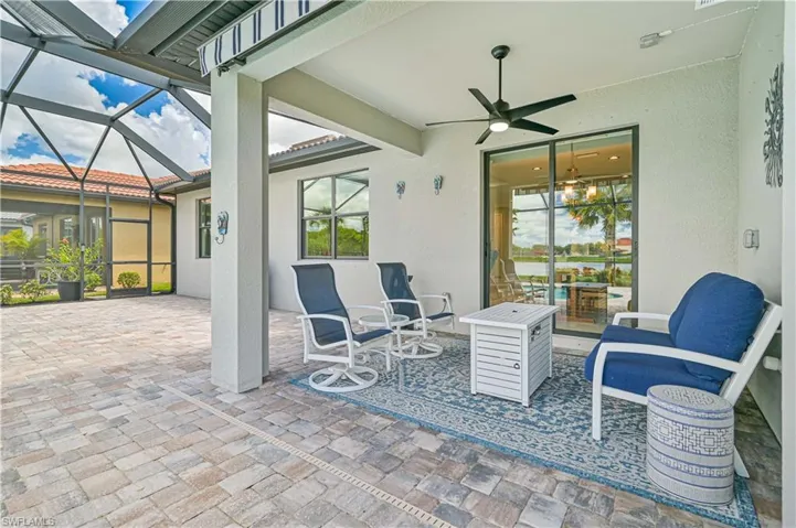 View of patio featuring glass enclosure and ceiling fan