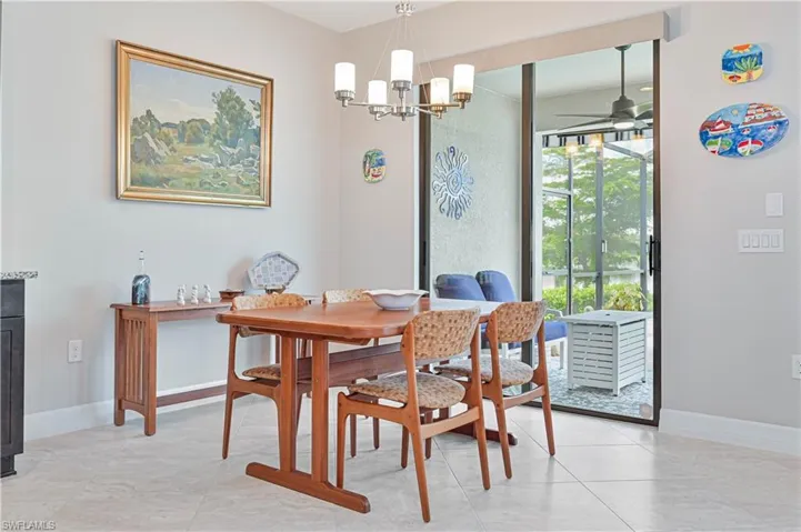 Dining space featuring ceiling fan with notable chandelier and light tile patterned floors