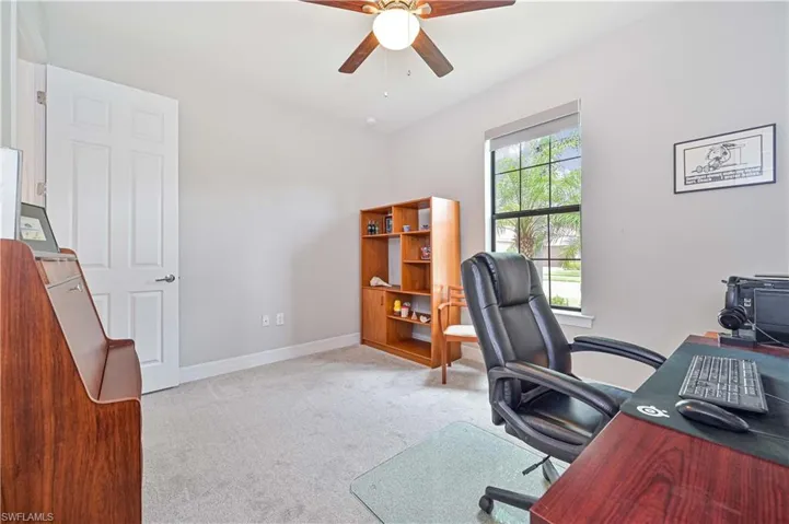 Carpeted office space featuring ceiling fan