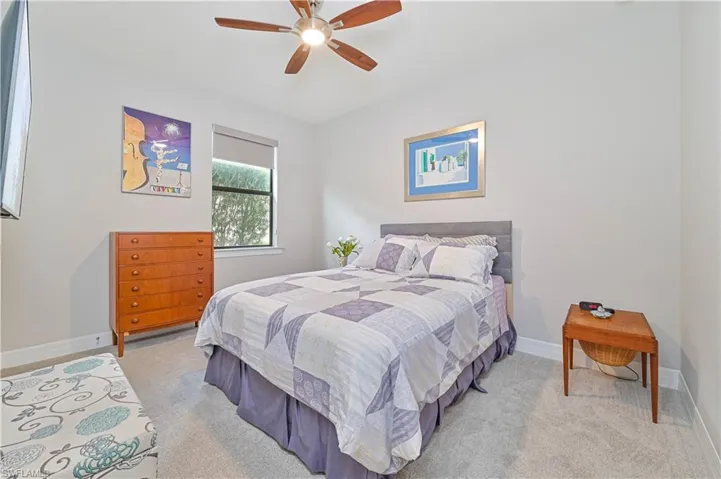 Bedroom with light colored carpet and ceiling fan