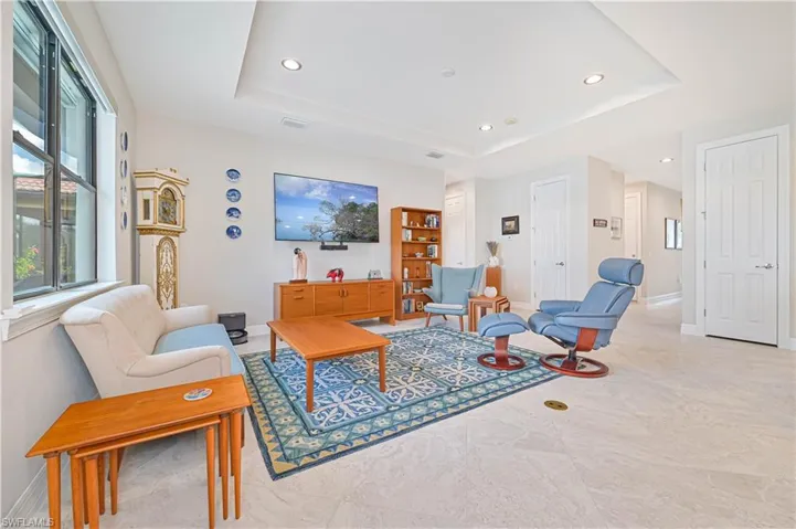 Living room featuring light tile patterned floors and a tray ceiling