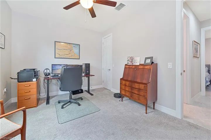 Office space featuring light colored carpet and ceiling fan