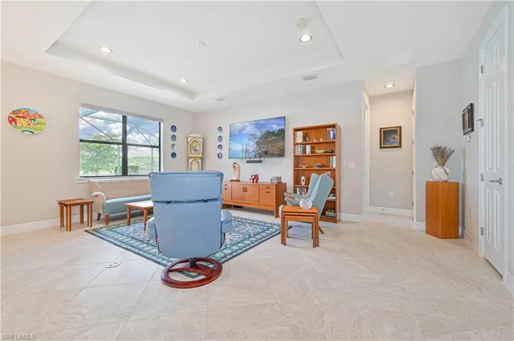 Tiled living room featuring a raised ceiling