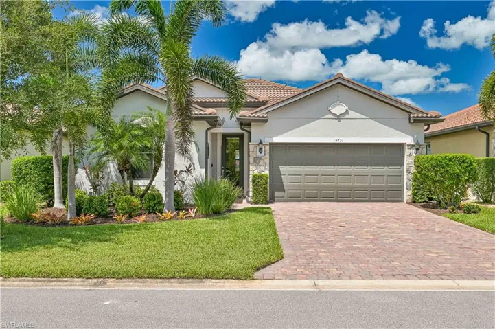 View of front of home with a garage and a front lawn
