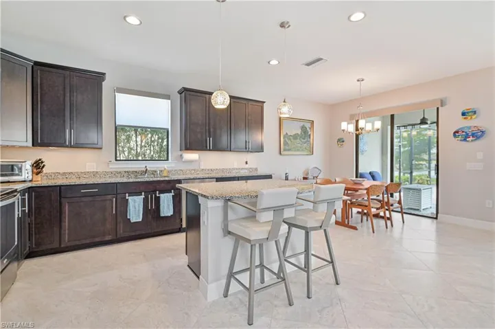 Kitchen with plenty of natural light, light stone counters, and light tile patterned floors