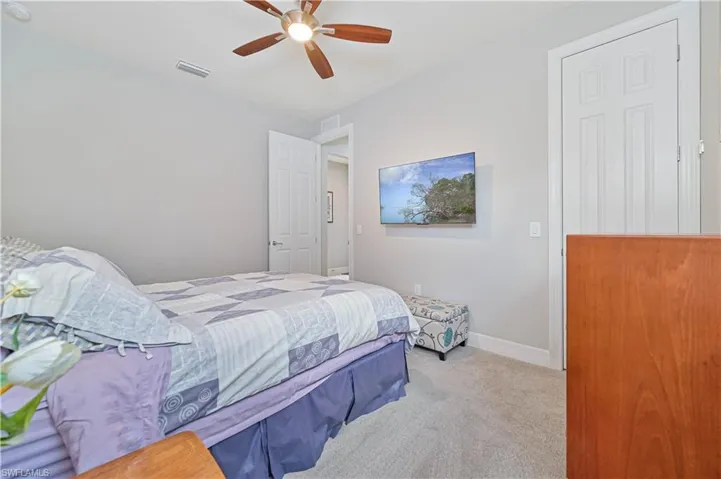Carpeted bedroom with ceiling fan