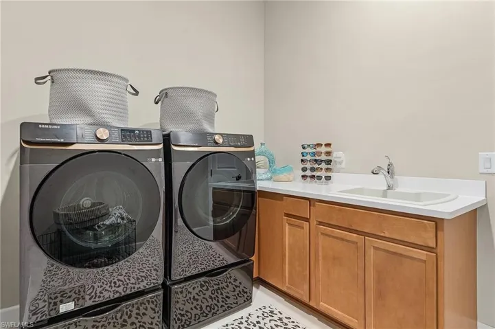 Laundry area featuring cabinets, sink, and separate washer and dryer