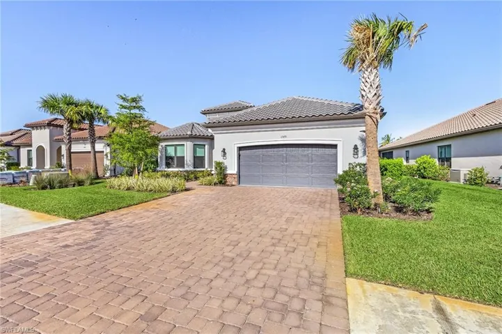 Mediterranean / spanish home with a front yard and a garage