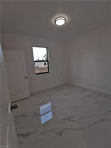 Corridor with light marble finish flooring and recessed lighting