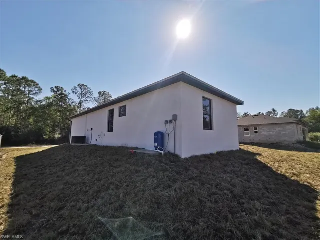 View of home's exterior with stucco siding and a lawn