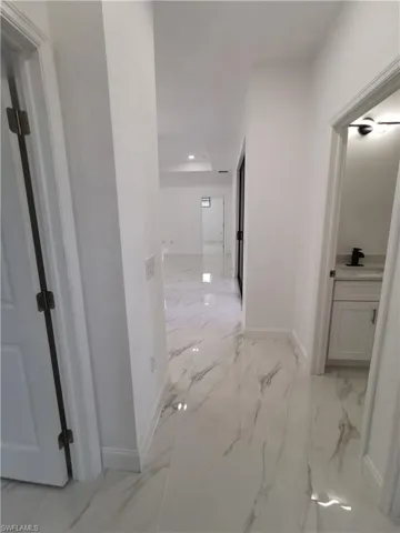 Half bathroom with vanity and light marble finish floors