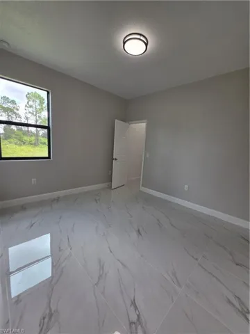 Hallway with light marble finish flooring and recessed lighting