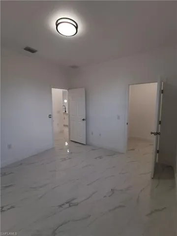 Empty room featuring baseboards and light marble finish floors