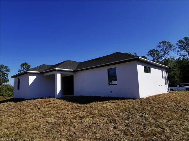 View of side of home featuring stucco siding and a lawn