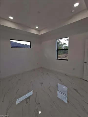 Unfurnished room featuring recessed lighting and light marble finish flooring