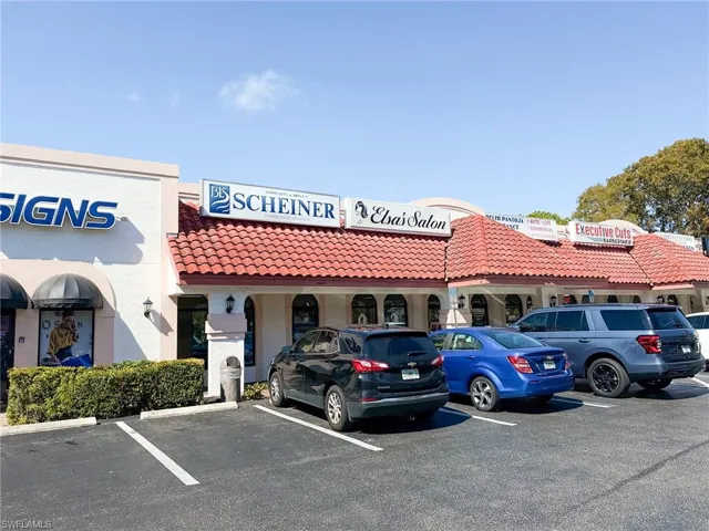 View of building exterior with uncovered parking