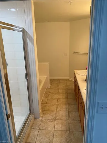 Bathroom with double vanity, plus walk in shower, and tile patterned floors