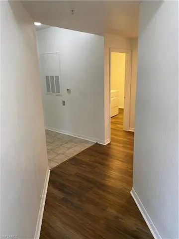 Corridor with dark hardwood / wood-style floors