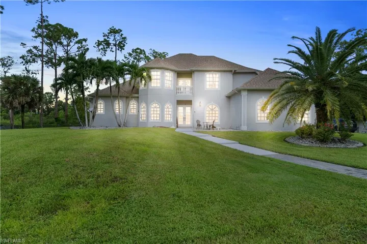 View of front facade featuring a front yard, french doors, and stucco siding
