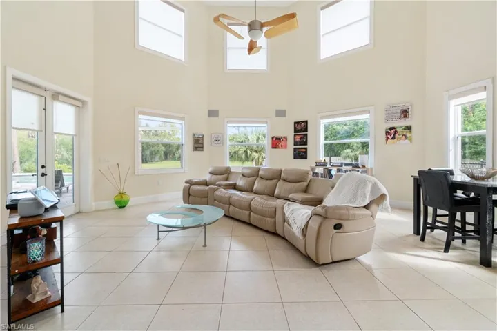 Living room featuring ceiling fan, baseboards, and light tile patterned flooring