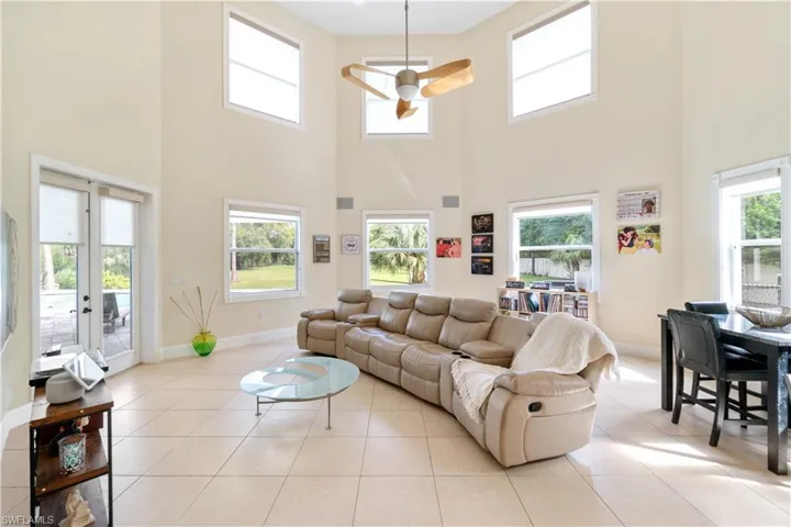 Living area with french doors, baseboards, and light tile patterned floors