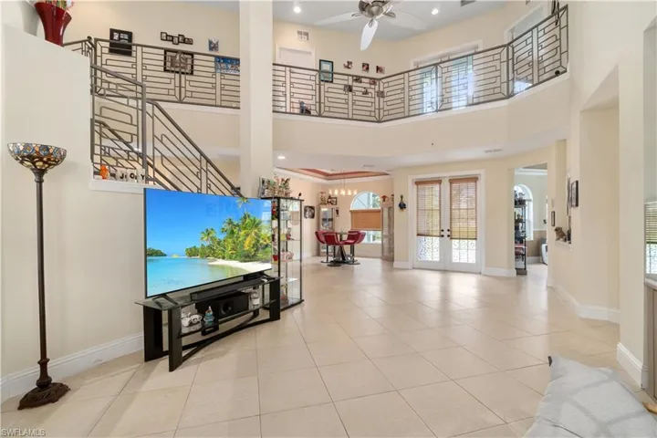 Living room featuring french doors, a high ceiling, and baseboards