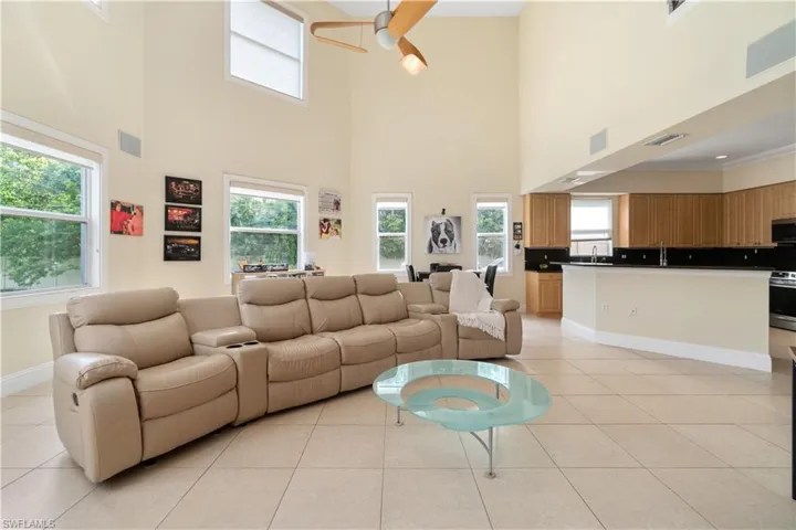 Living room featuring light tile patterned flooring, visible vents, and a healthy amount of sunlight