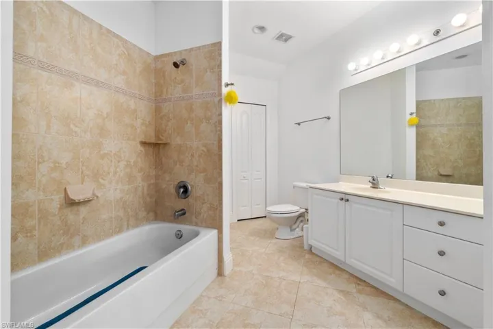 Full bathroom featuring visible vents, toilet, vanity, tile patterned floors, and shower / bathtub combination