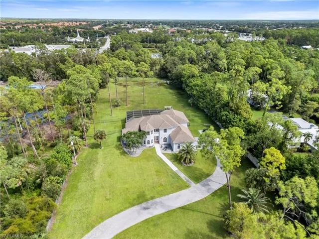 Birds eye view of property featuring a wooded view