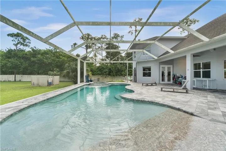 View of swimming pool with french doors, a yard, a pool with connected hot tub, a patio area, and fence