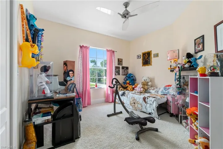 Carpeted office featuring a ceiling fan